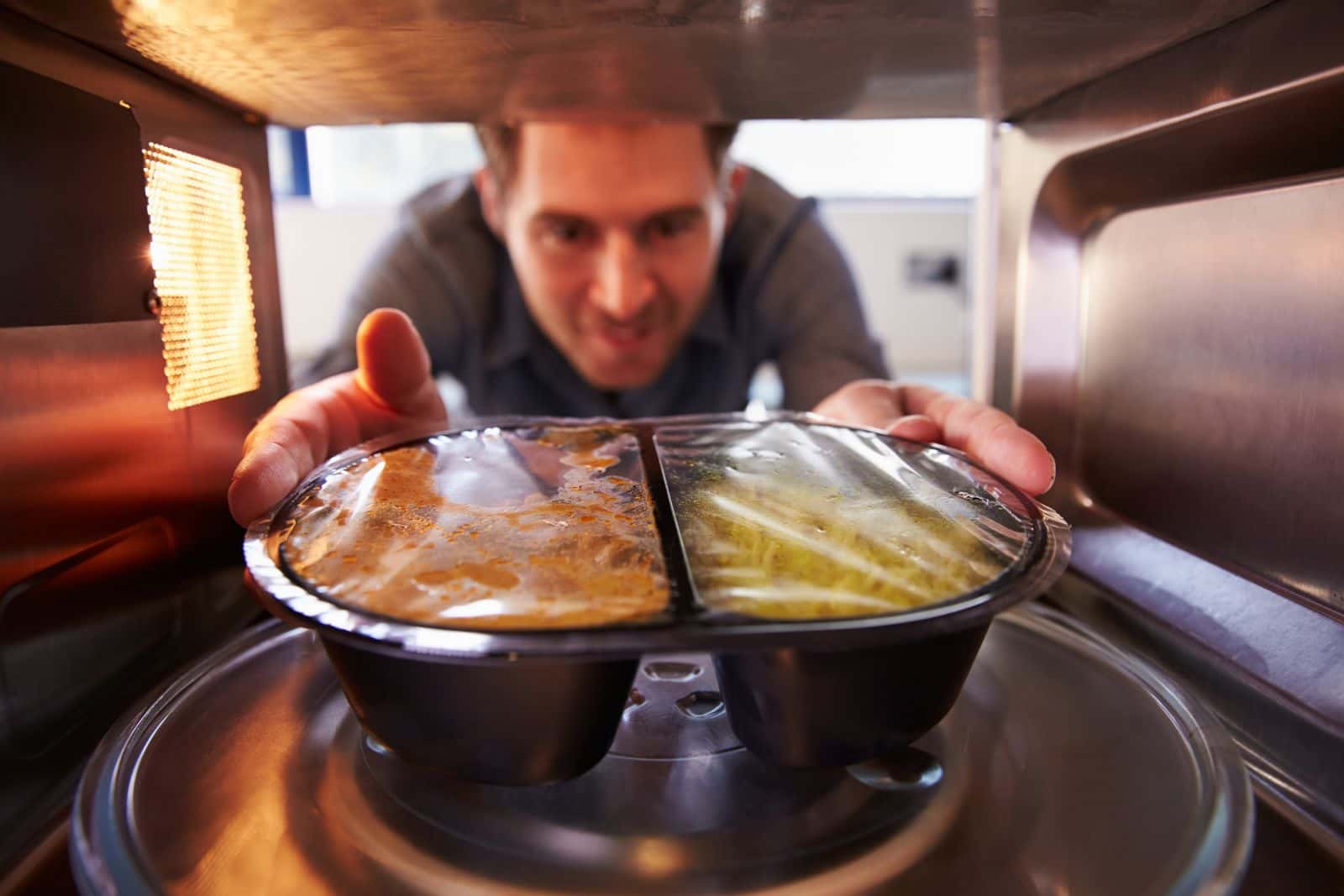 bigstock-man-microwave-dinner-into-mic-77372021-1538137808942.jpg