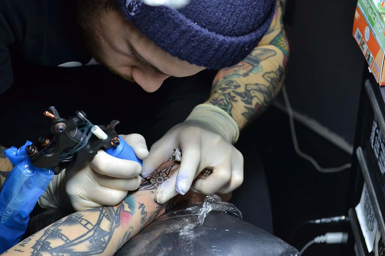 1280px-Italian-tattoo-artist-at-work