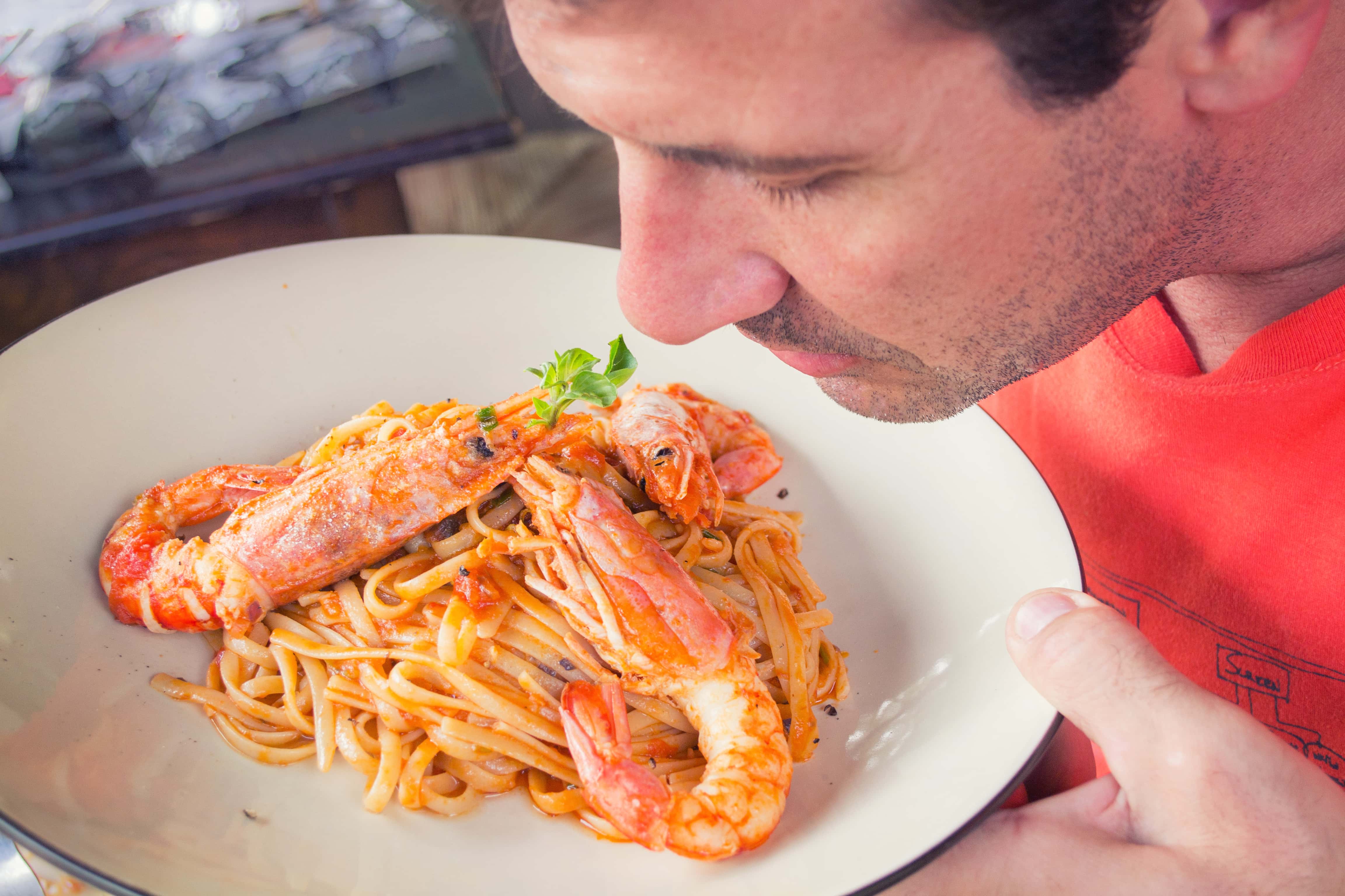 Canva - Man Smelling Prawn and Pasta Dish on White Ceramic Plate