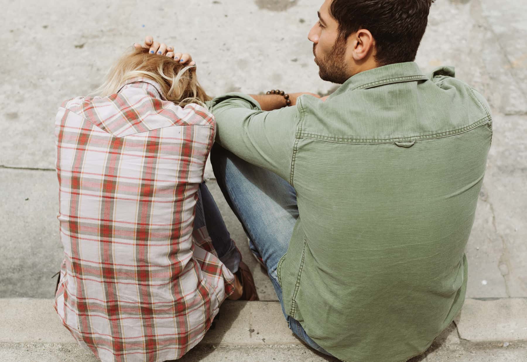 Canva - Man and Woman Sitting on Sidewalk
