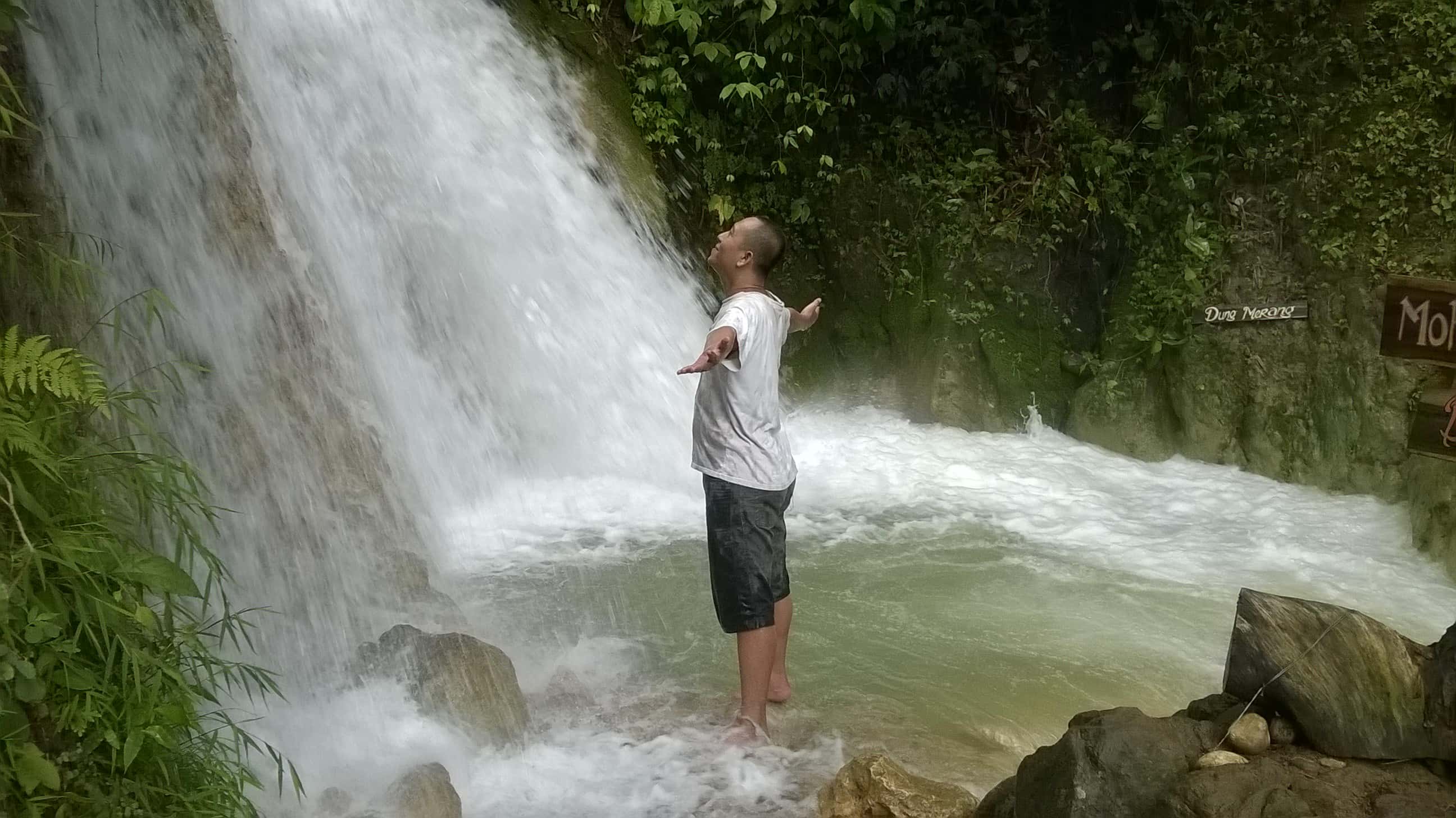 Canva - Man standing at the waterfalls