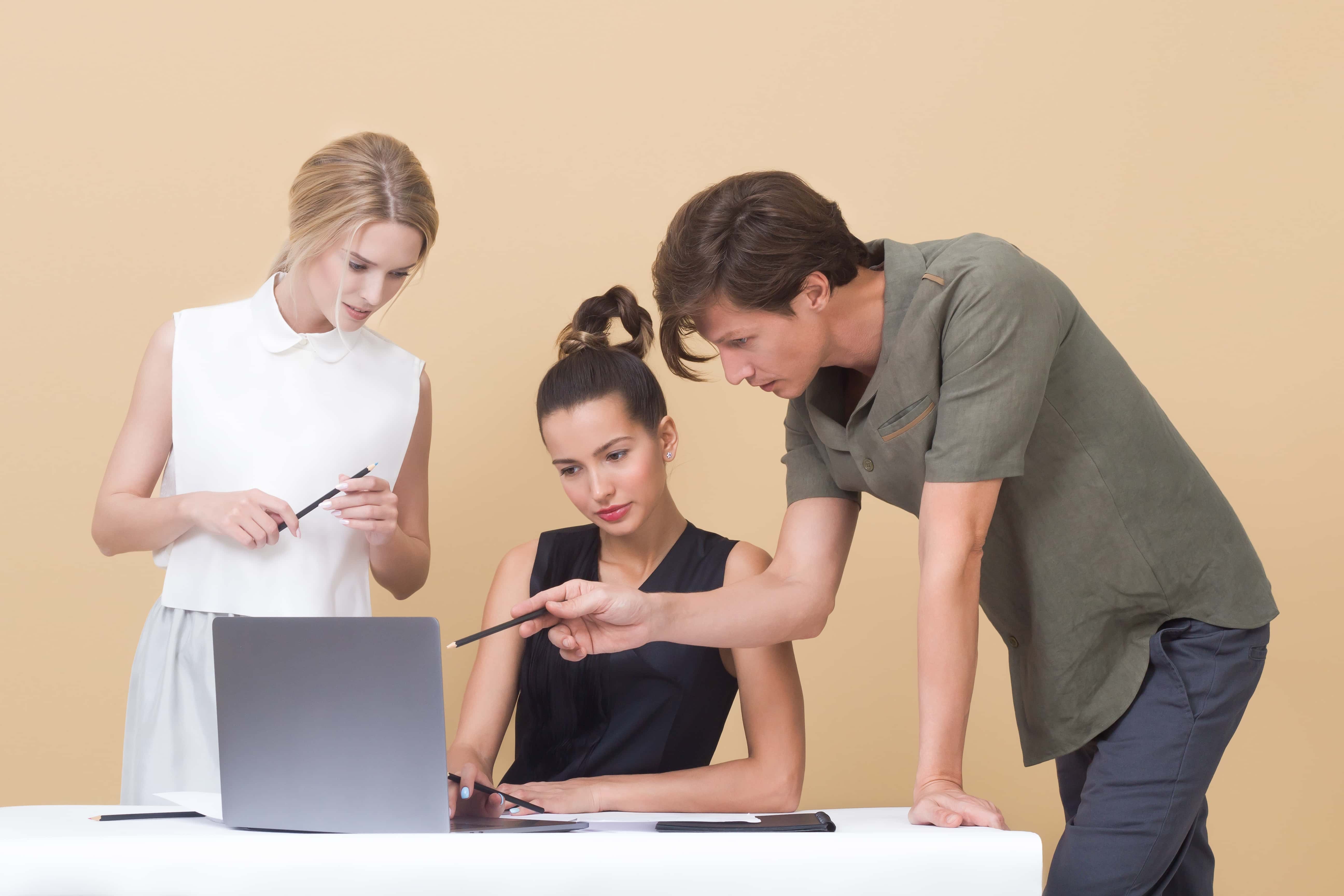 Canva - Two Woman and One Man Looking at the Laptop