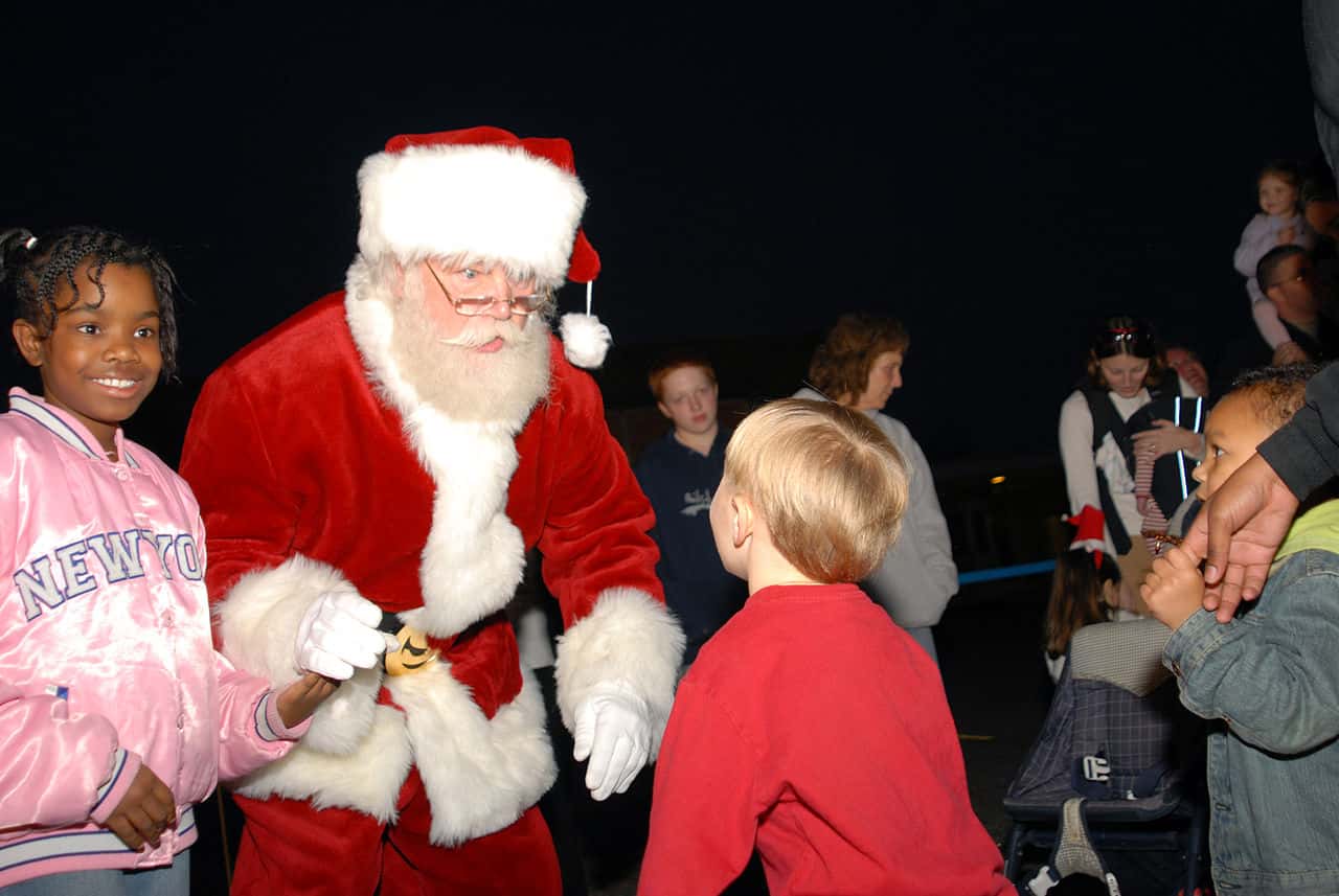 1280px-US_Navy_061127-N-7987M-039_Santa_greets_his_guest_during_Operation_Christmas_at_the_Army_National_Guard_Armory