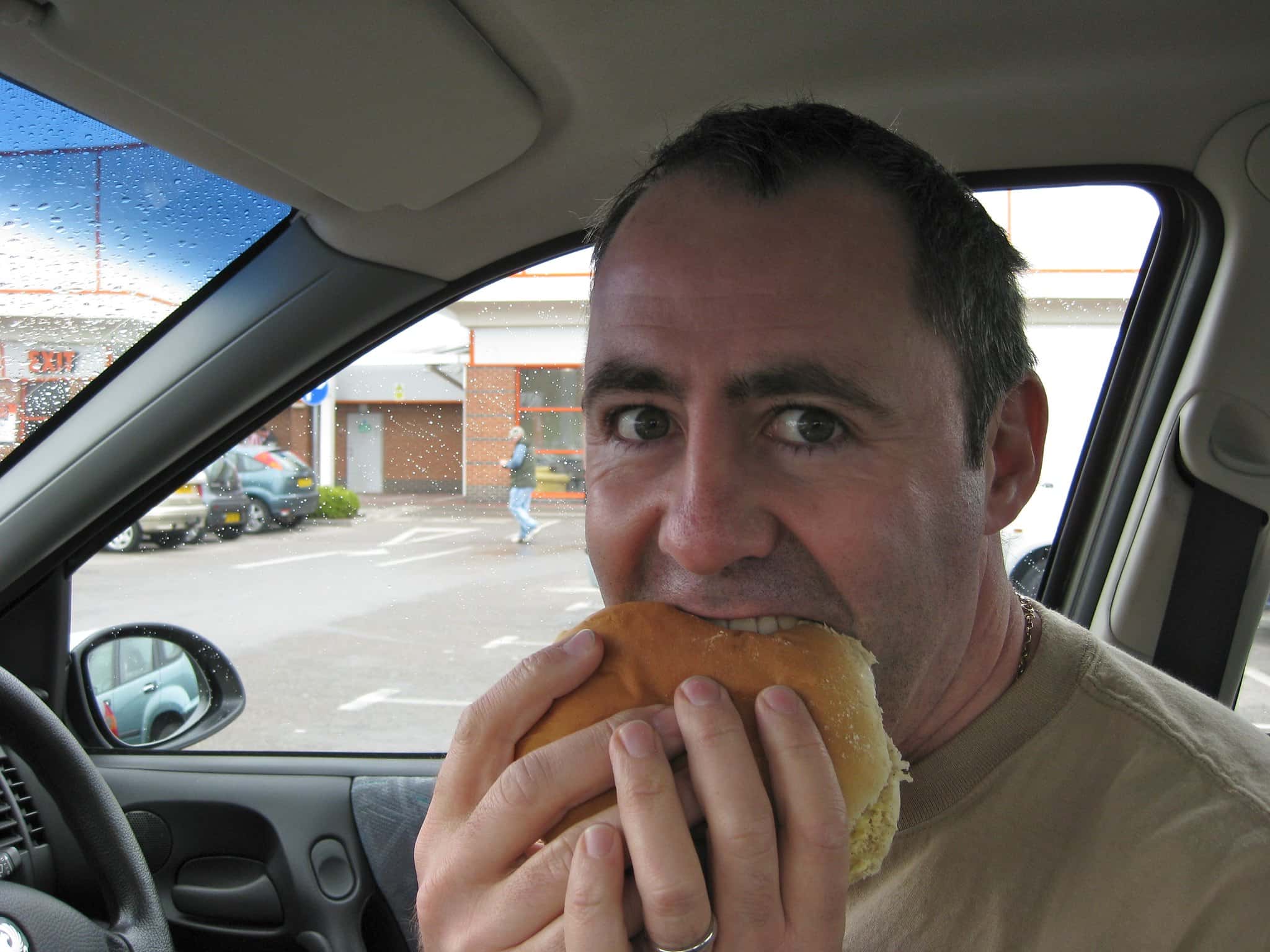 Man eats burger in a car