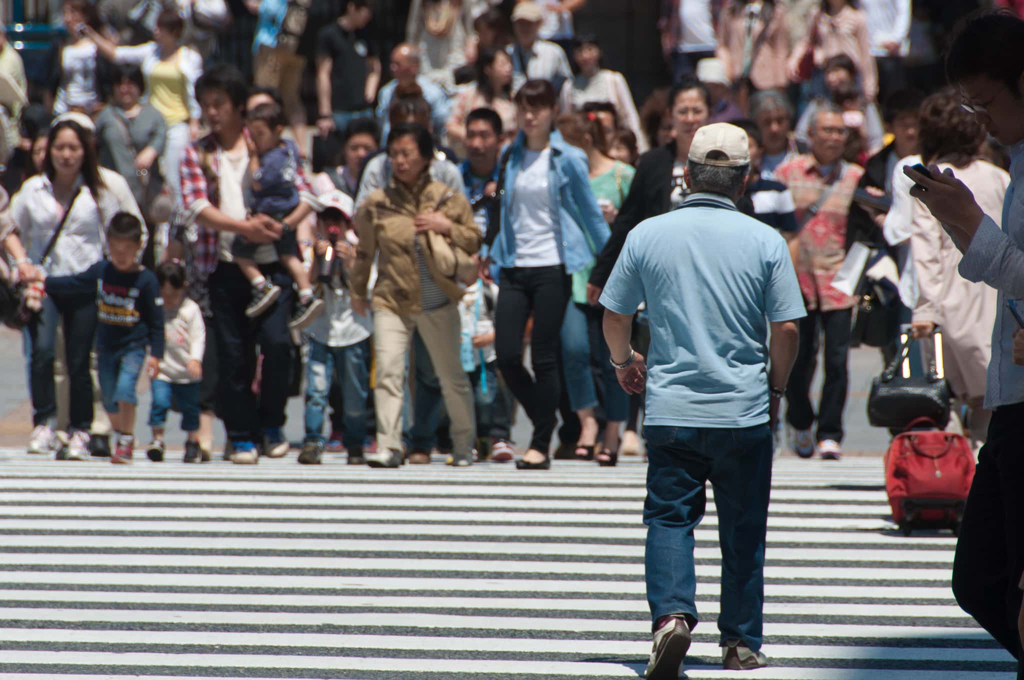A man walks into the crosswalk near the Ueno JR train station in Tokyo, Japan.