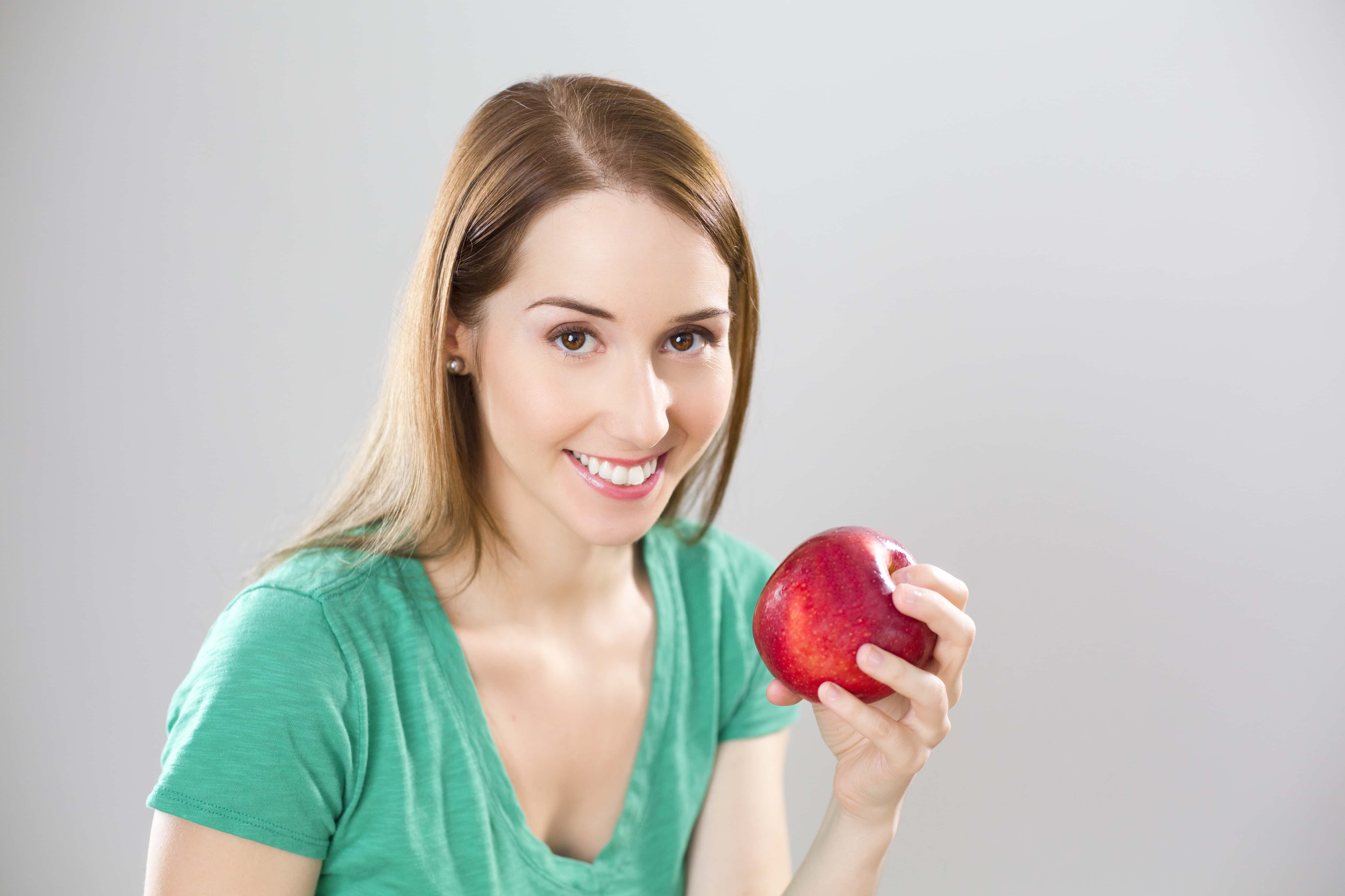 Canva - Portrait of Young Woman Eating Fruit Against White Background