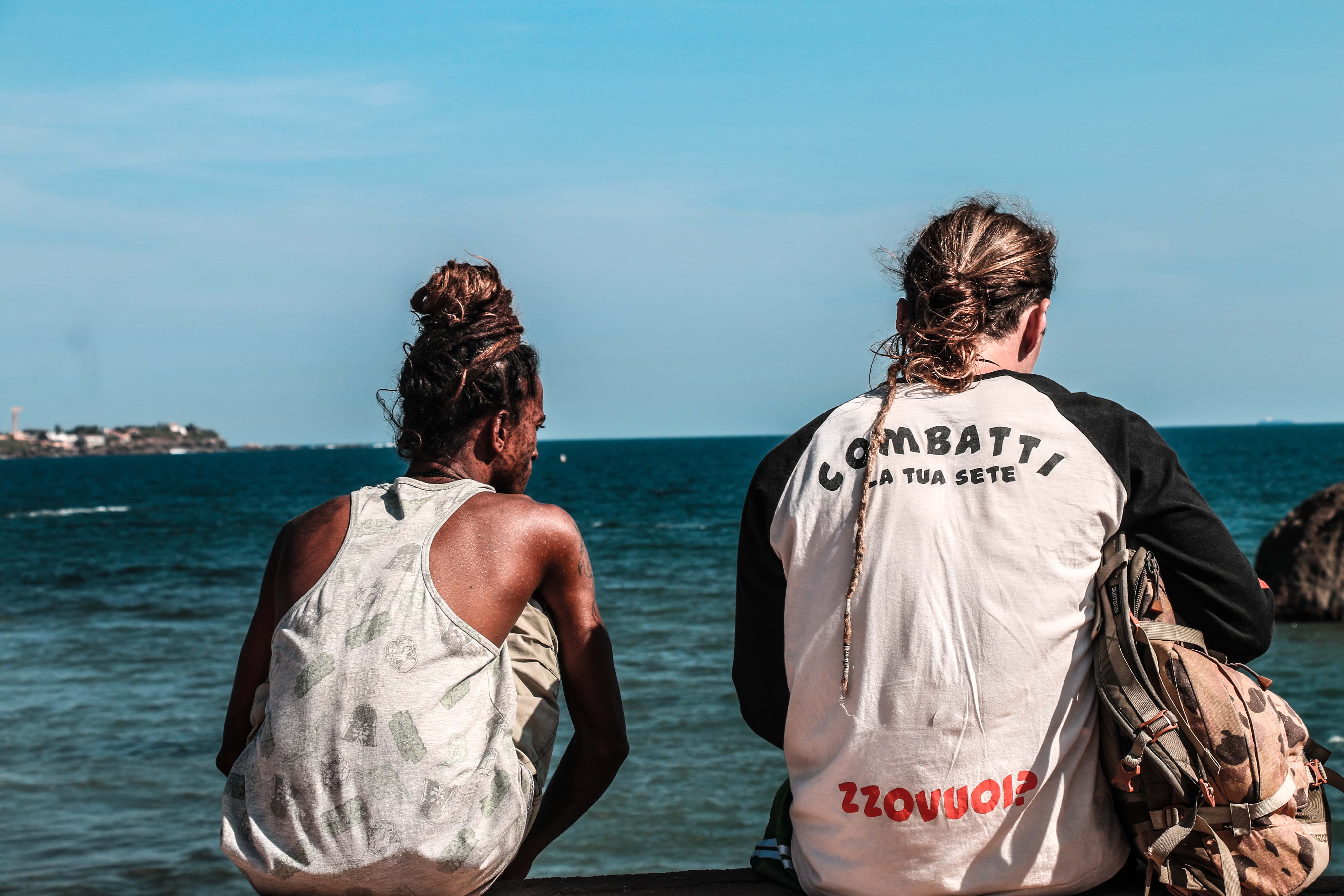 Canva - Two Man Sitting on Seawall in Front of Seashore