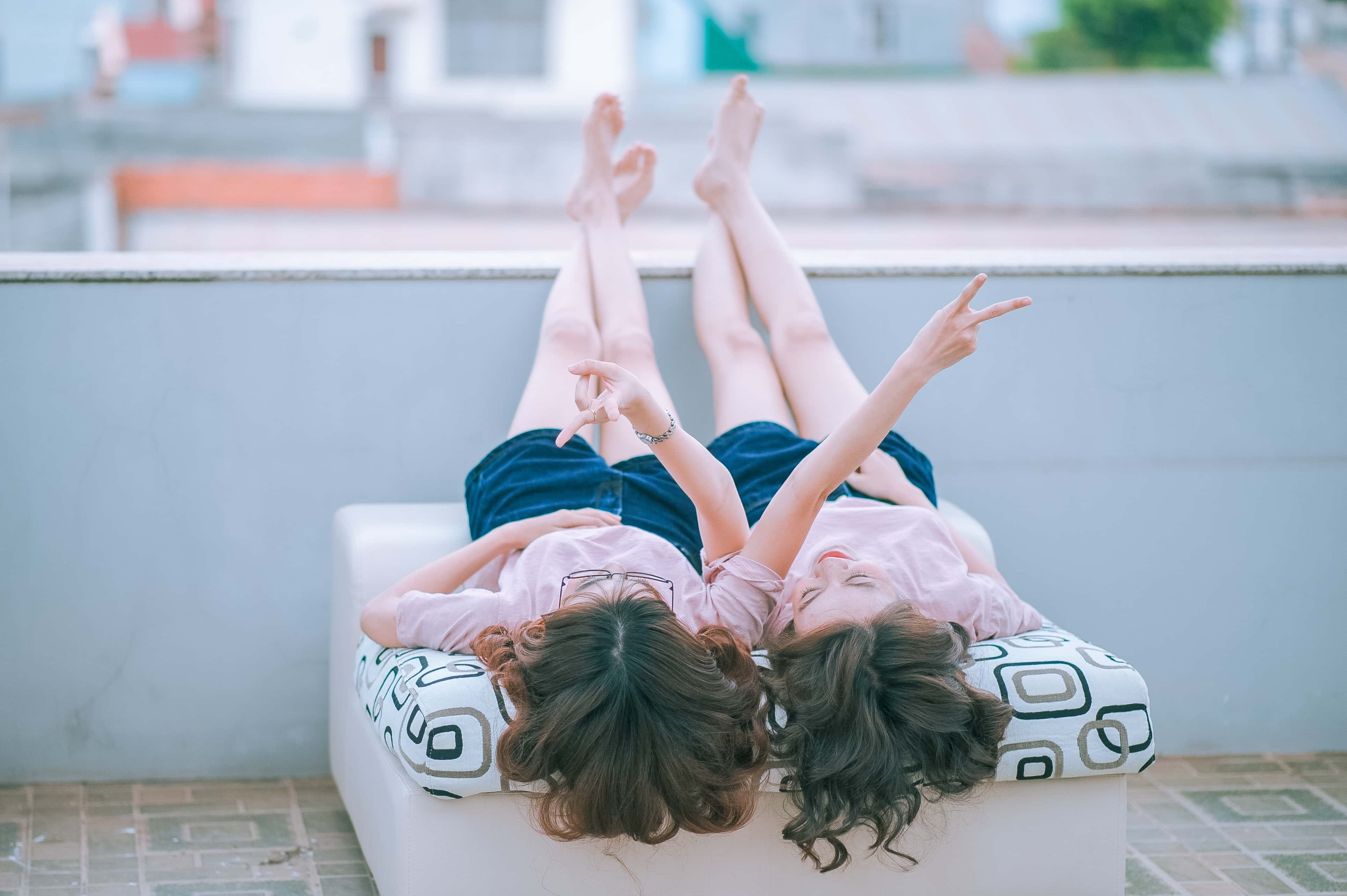 Canva - Two Women Lying on White Mattress