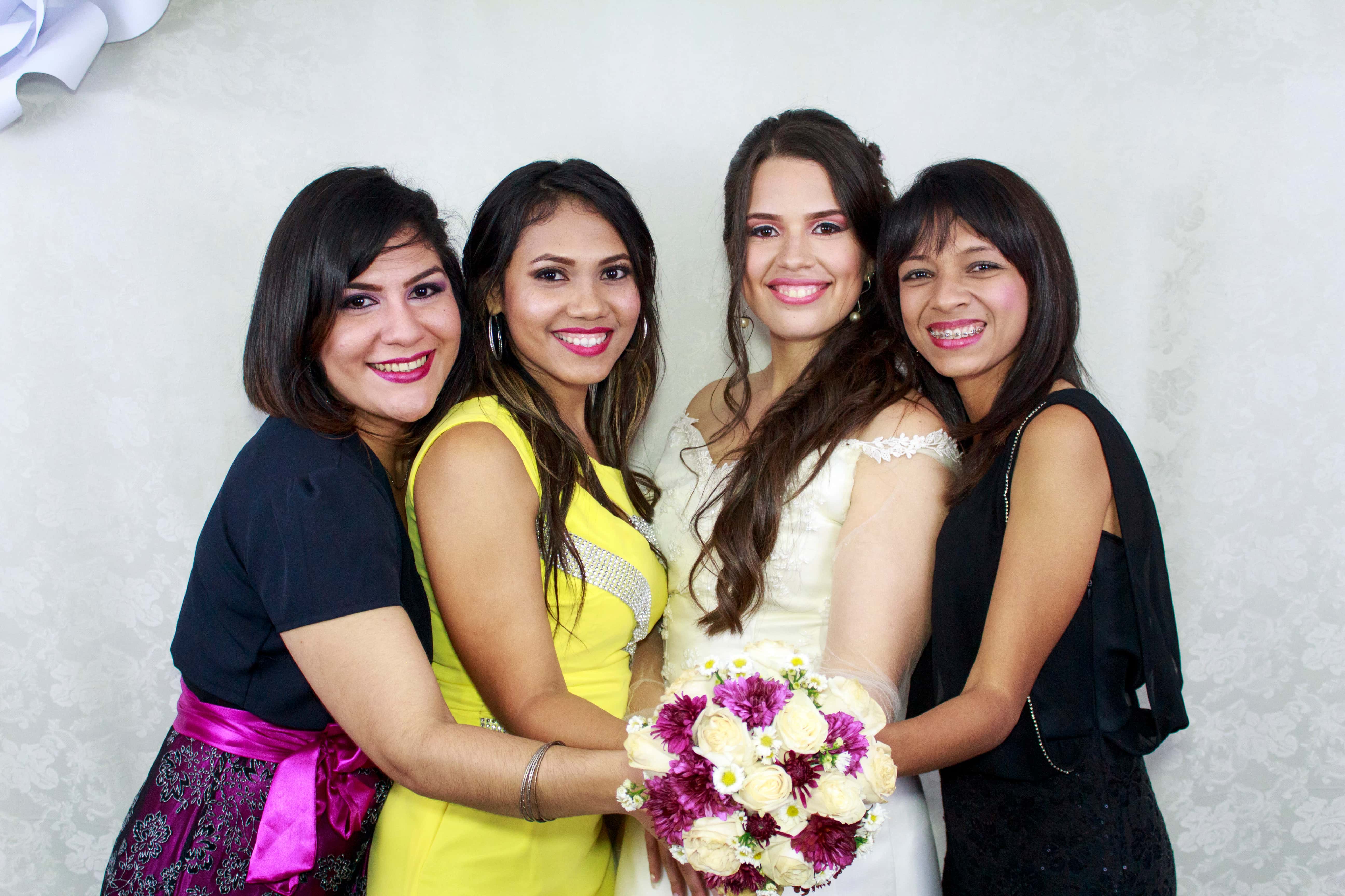 Canva - Woman in Beige Wedding Dress Holding Bouquet Flower Together With Other Three Woman in Assorted Colors of Dresses