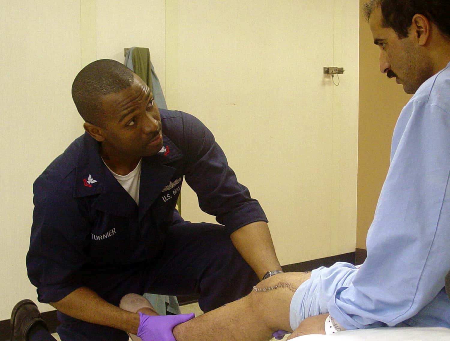 US_Navy_030425-N-4128M-001_U.S._Navy_Physical_Therapy_Technician_Jean_Pierre_Turnier_examines_an_unidentified_Iraqi_patient_aboard_USNS_Comfort
