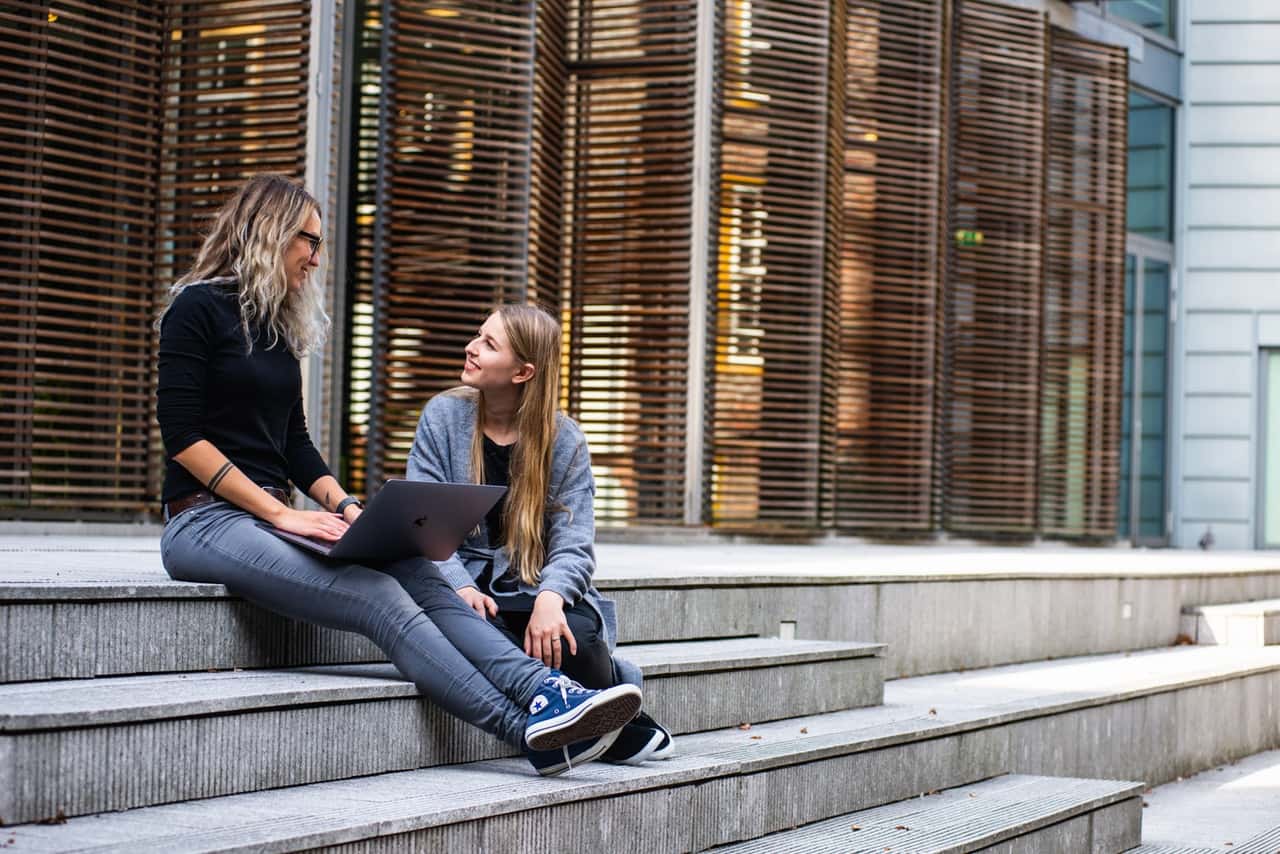 two-women-having-conversation-on-stairs-1438084