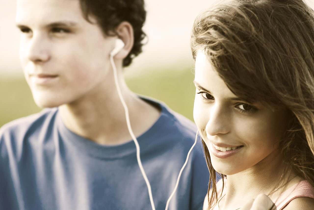 1280px-Teens_sharing_a_song