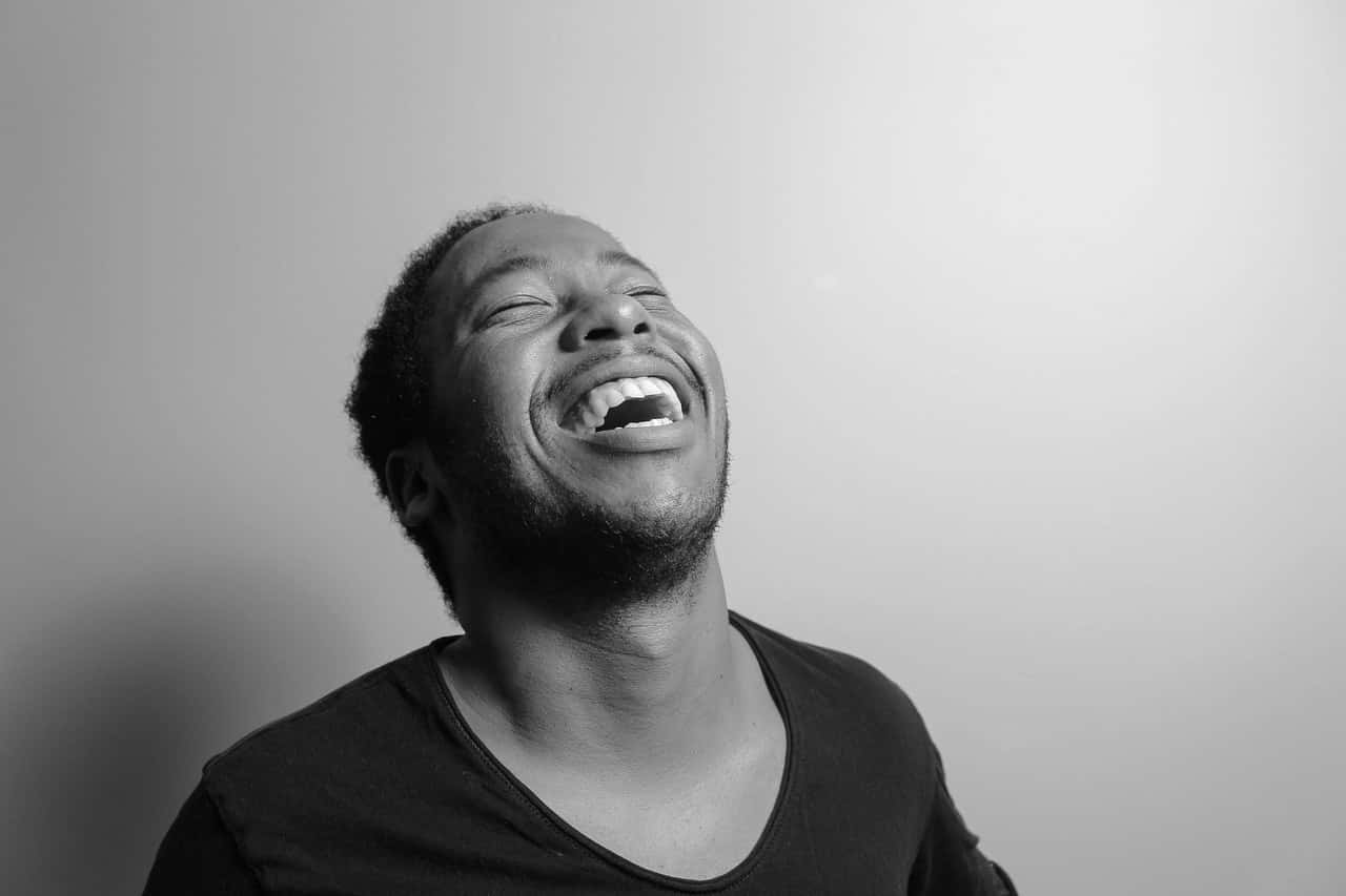 grayscale-photograph-of-man-laughing-1498338