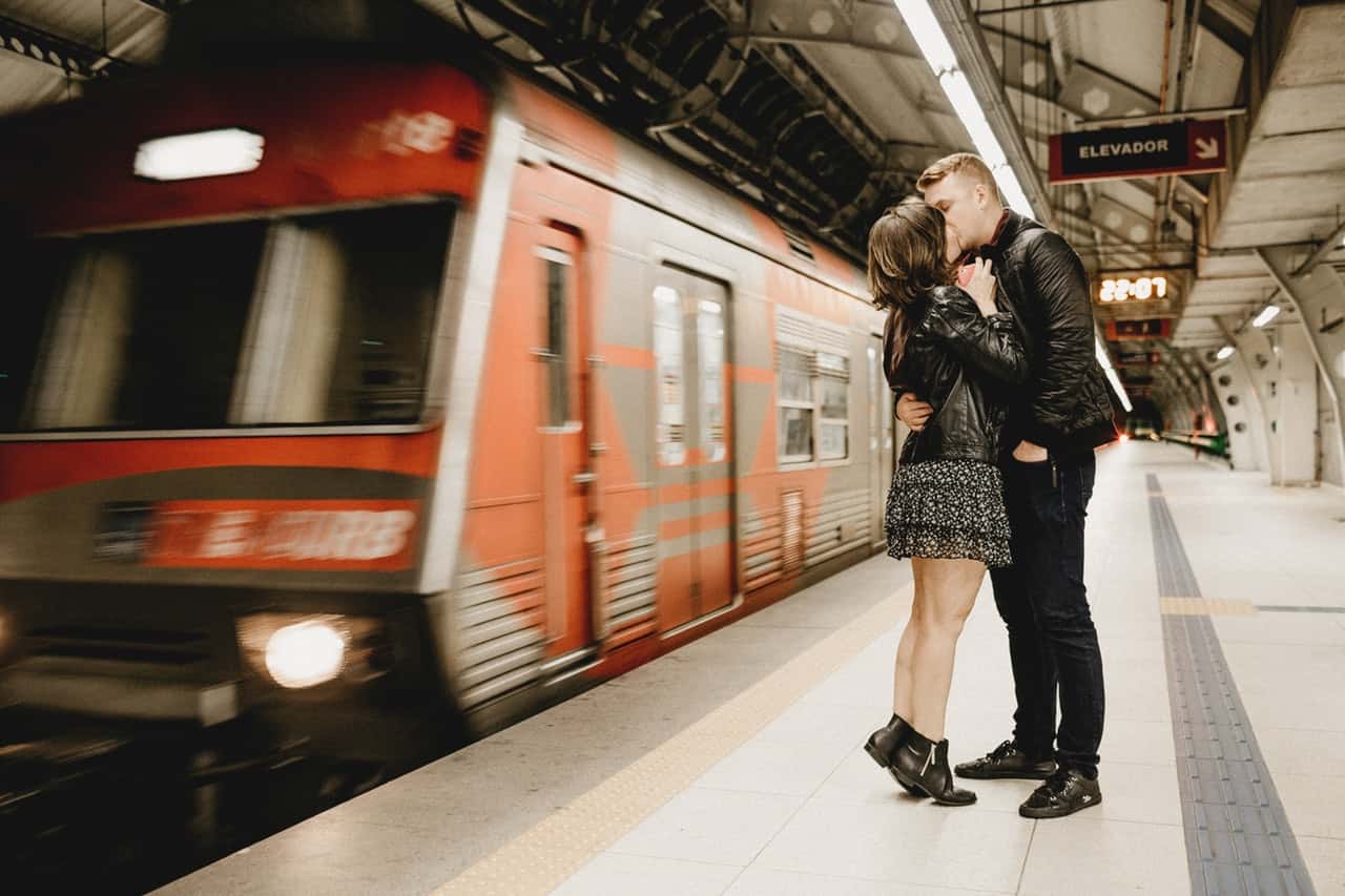 kissing-couple-beside-running-train-in-subway-3134229