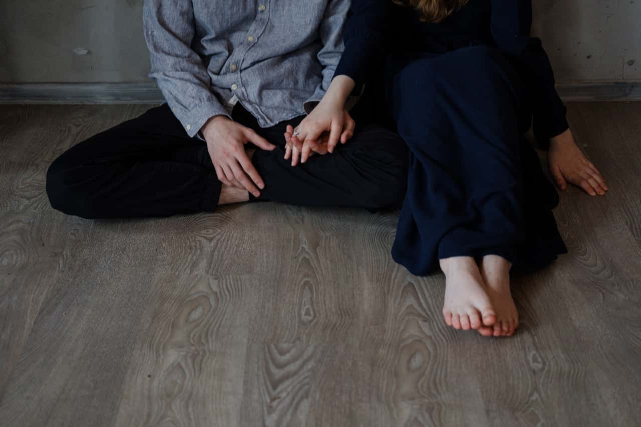 man-and-woman-sitting-on-wooden-floor-1959309