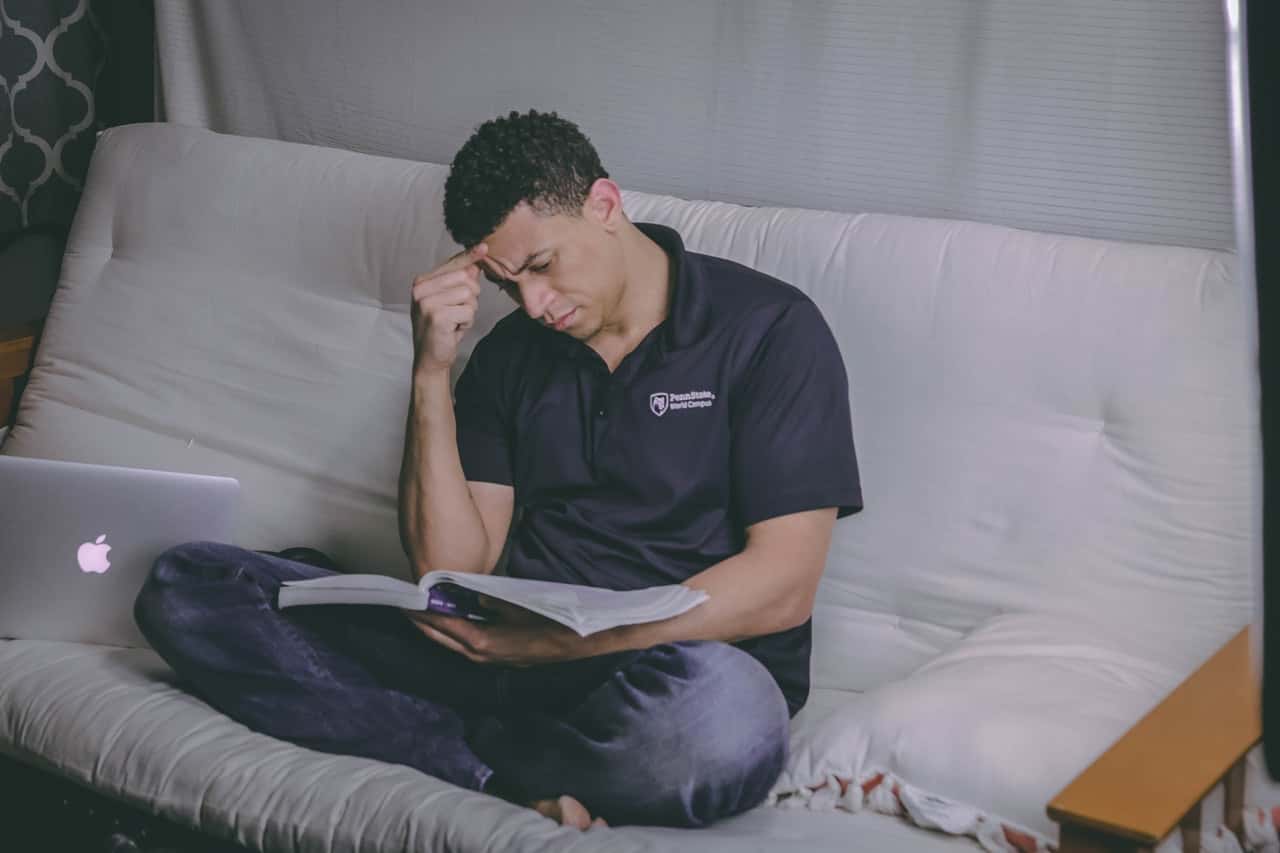 man-sitting-on-sofa-reading-book-1467564