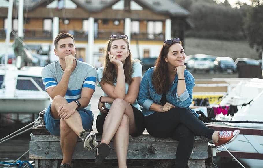 two-women-and-man-sitting-down-on-bench