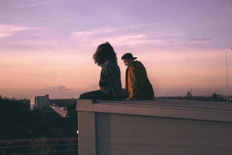 Canva - Young Couple Sitting on a Rooftop at Sunset