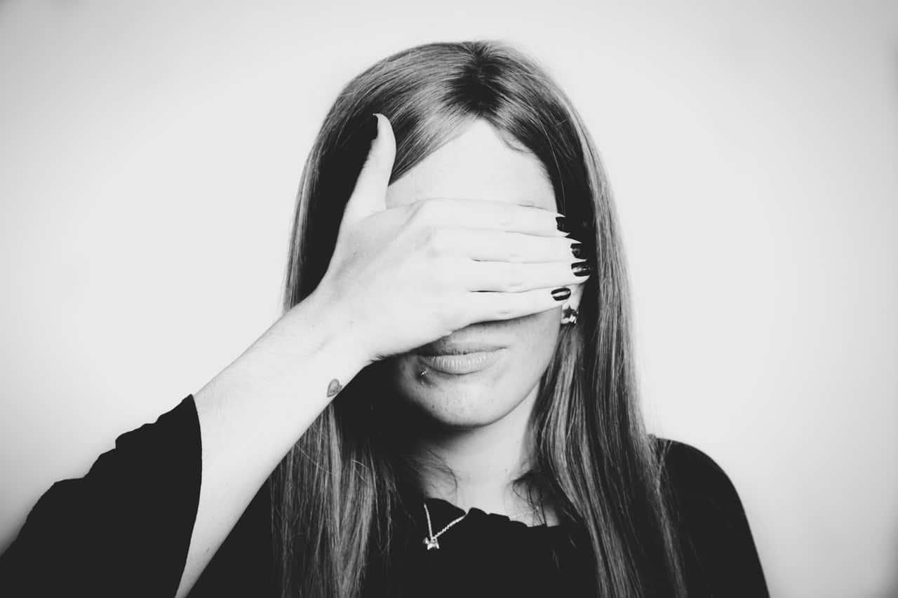 grayscale-photo-of-woman-covering-her-eyes-1669157