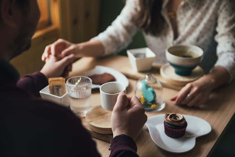 people-man-woman-couple-holding-hands-dinner