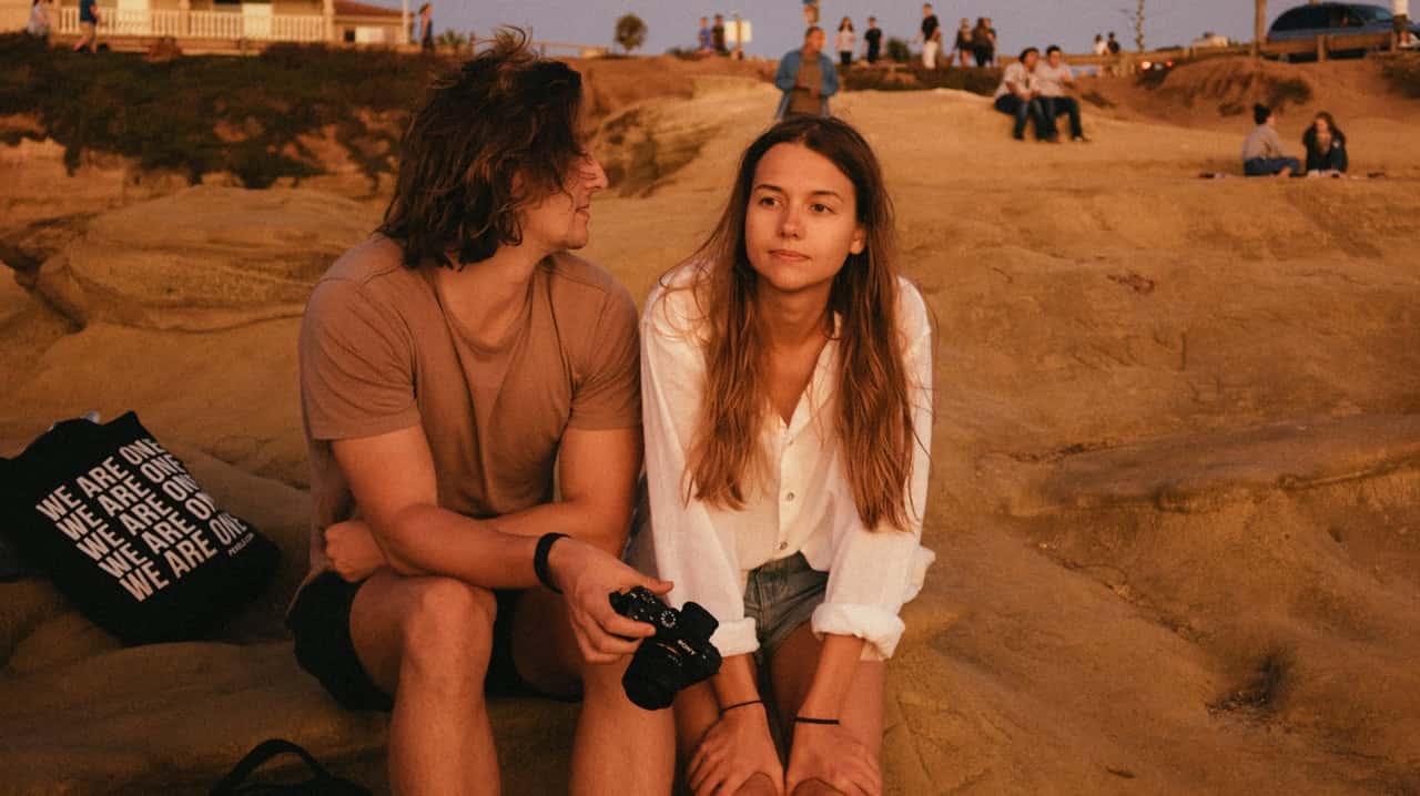 photo-of-man-and-woman-sitting-on-sand-2962243