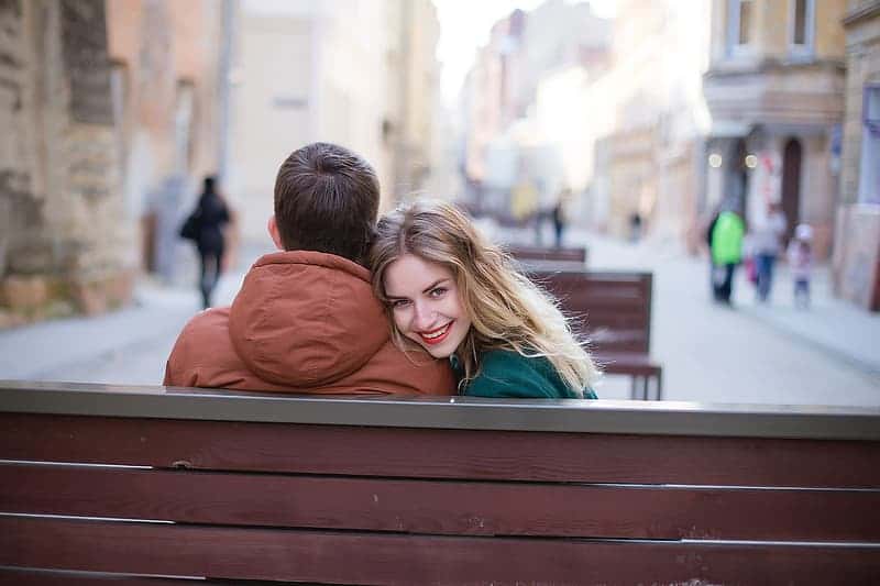 woman-smiling-beside-the-man-wearing-brown-hooded-jacket