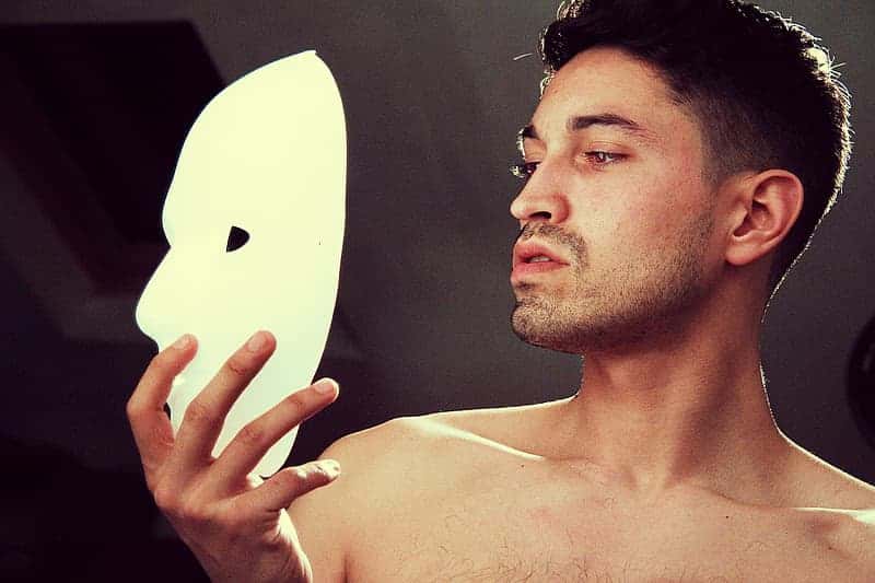 man-holding-a-white-mask