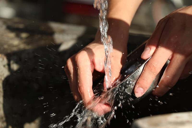 person-washing-bowl-in-flowing-water