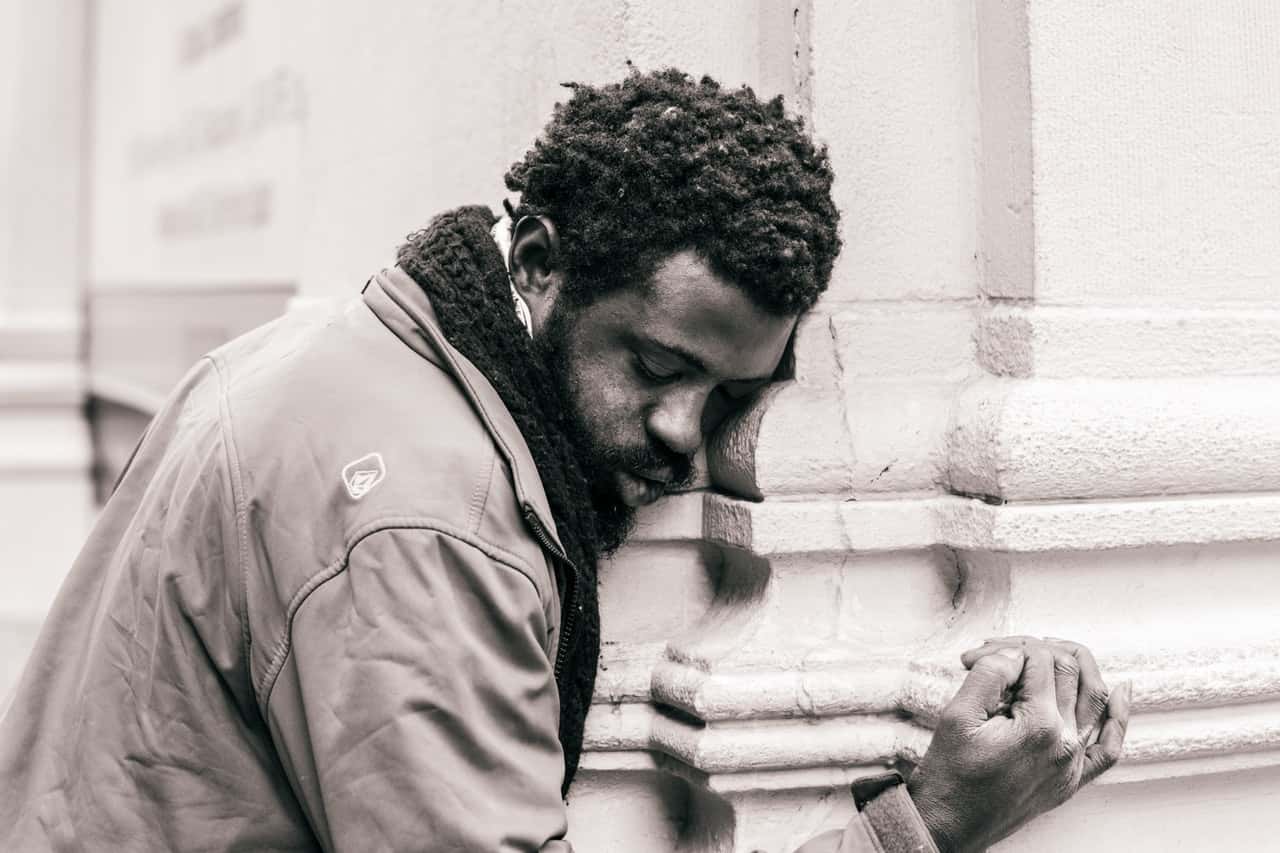 grayscale-photo-of-man-hugging-concrete-pillar-2250423