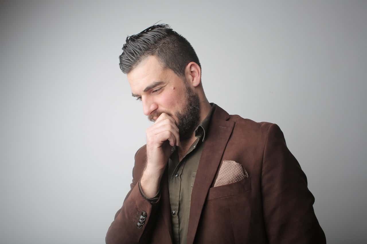 pensive-man-in-brown-coat-holding-his-chin-3785078