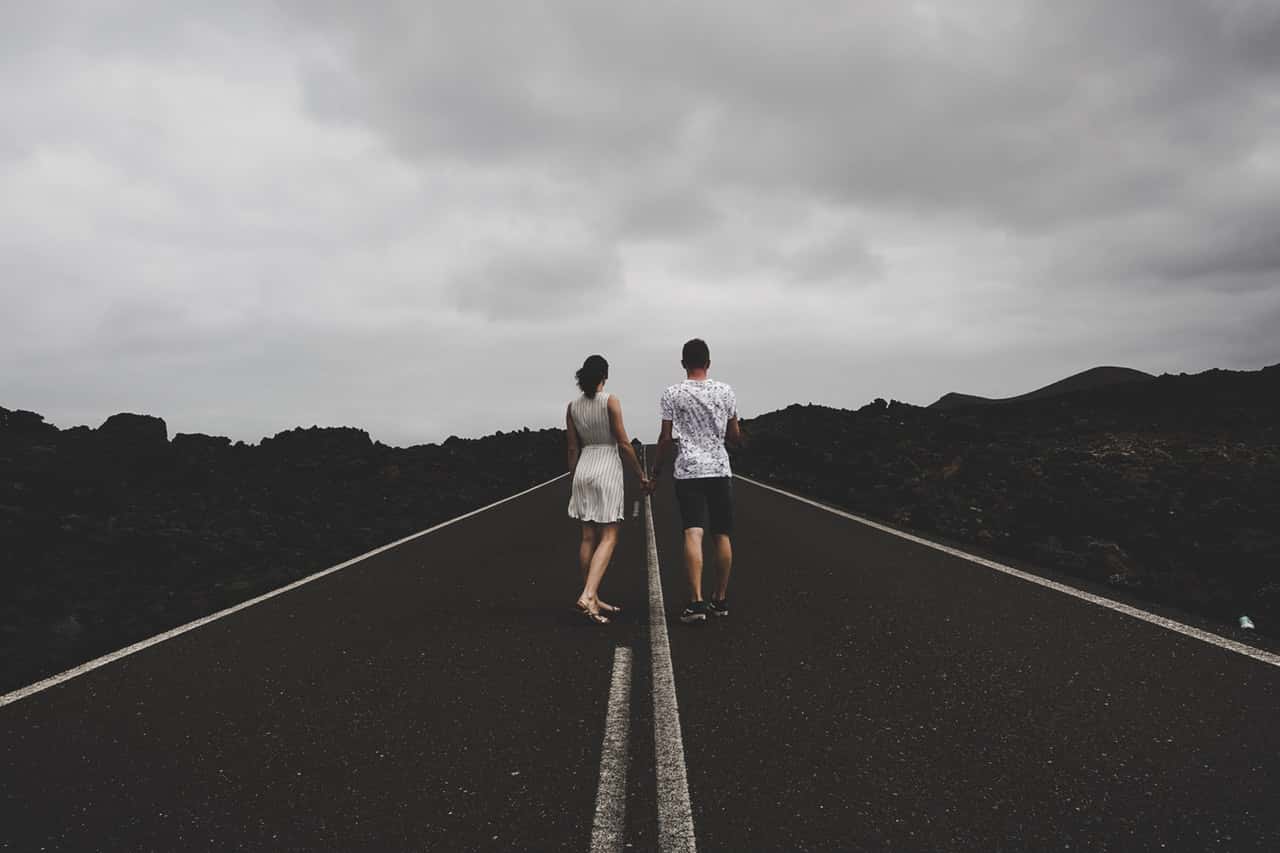 photo-of-couple-holding-hands-on-the-road-2828549