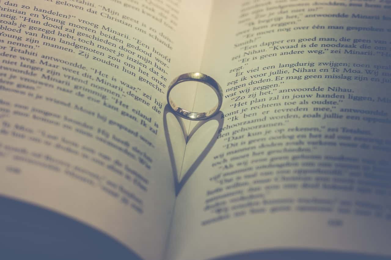 photography-of-silver-ring-on-book-776646
