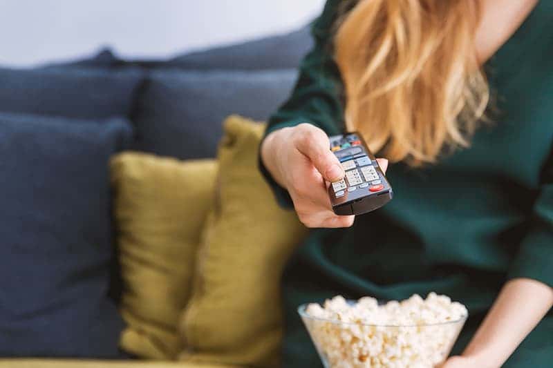 young-girl-with-tv-remote-and-a-popcorn-at-home