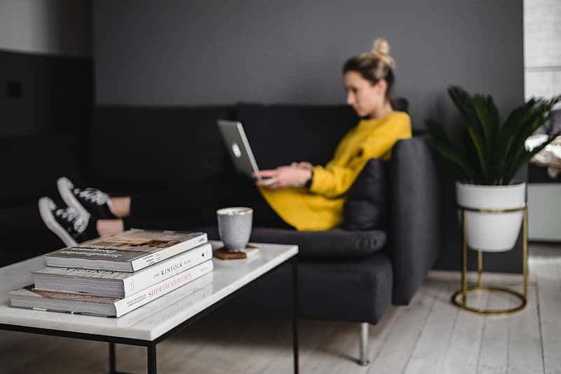 young-woman-sitting-on-the-sofa-and-working-on-her-laptop