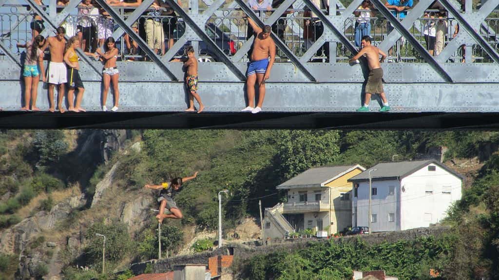 Kid_jumping_into_river_off_of_bridge_-_Porto_Portugal_(7933203320)