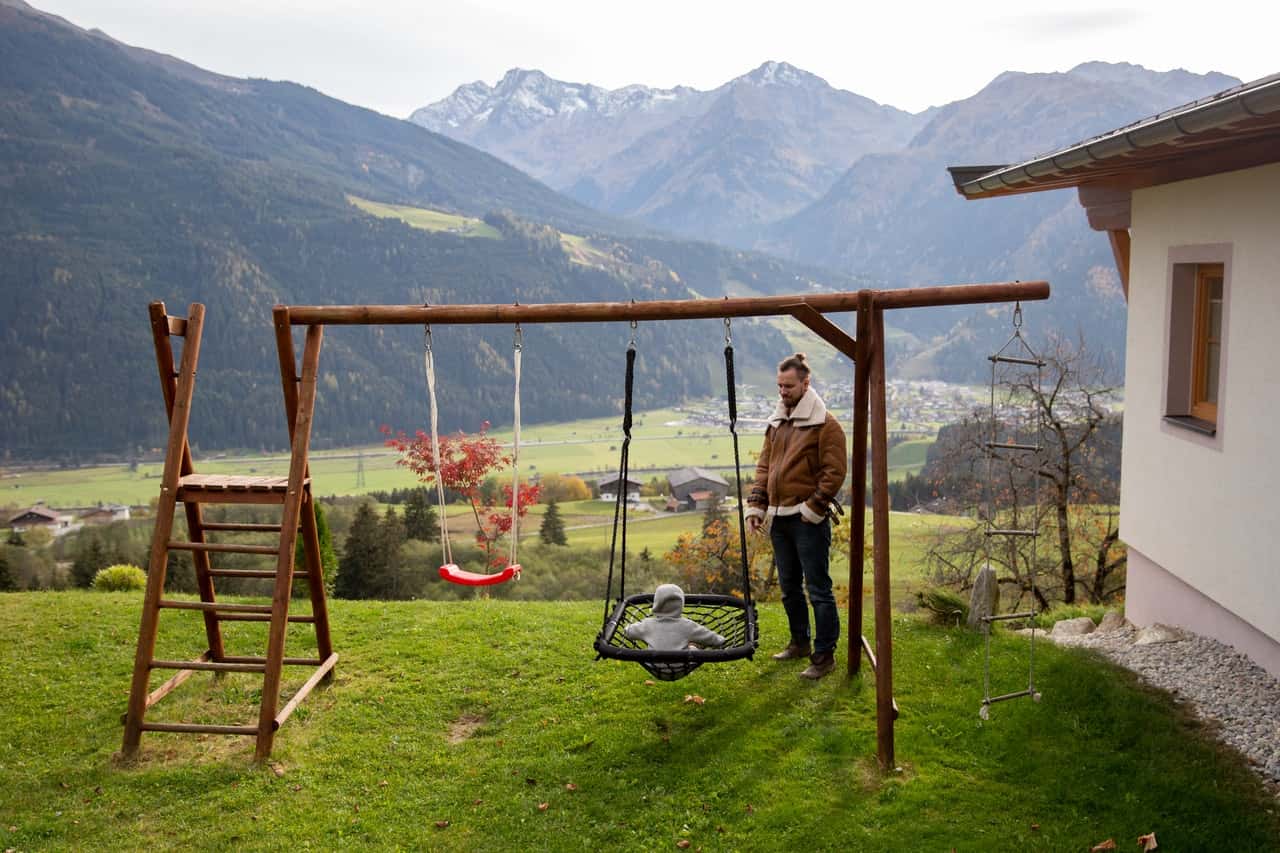 brown-wooden-swing-on-green-grass-field-near-mountains-3933874