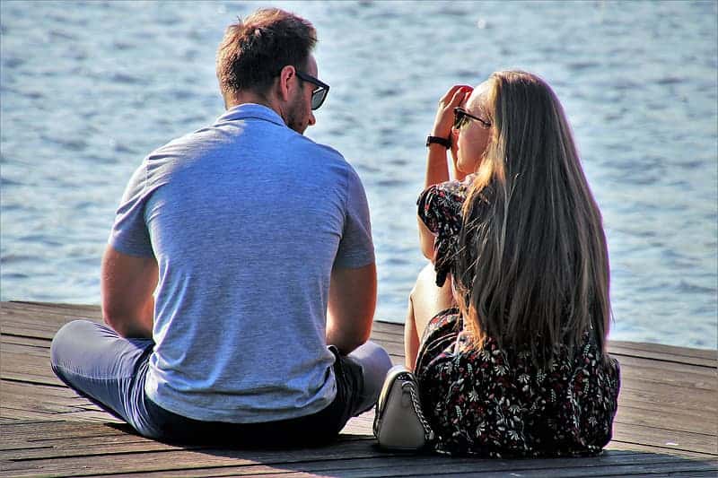 couple-sitting-on-wooden-dock-during-daytime