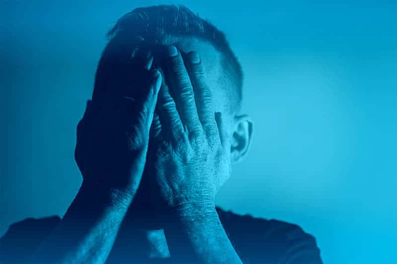 depression-sadness-despair-man-with-hands-covering-face-blue-tone