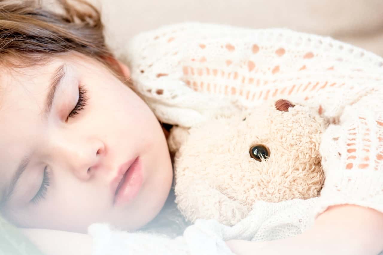 girl-sleeping-with-her-brown-plush-toy-101523