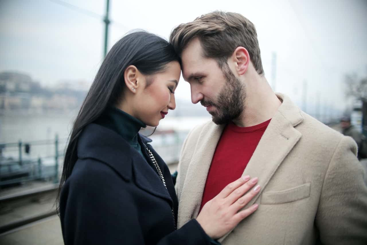 happy-multiracial-couple-hugging-on-waterfront-while-having-3775605
