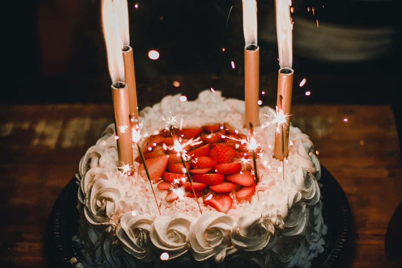 lighted-candles-on-white-icing-covered-cake-1729808