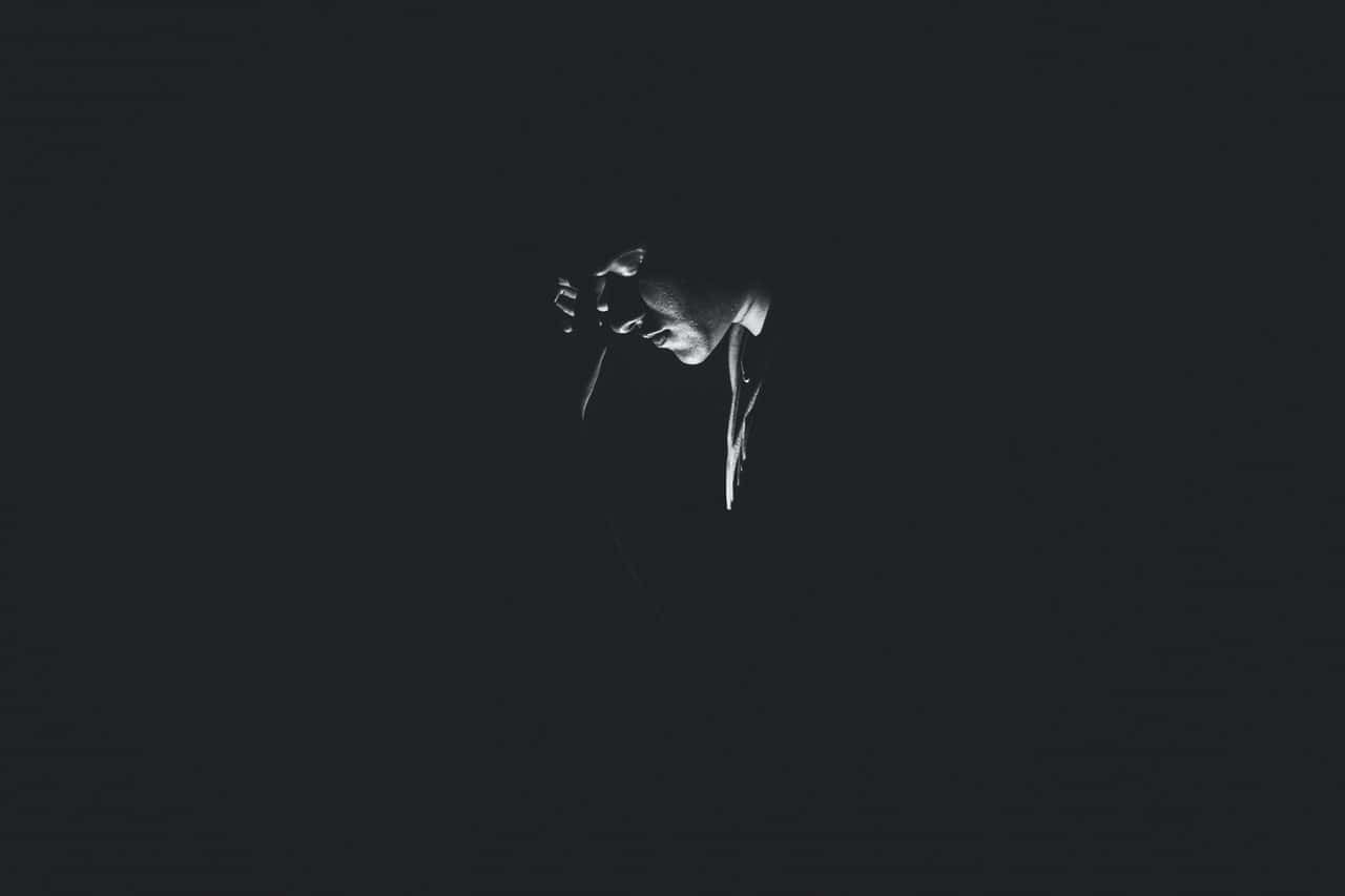 monochrome-photography-of-person-on-dark-room-1299417