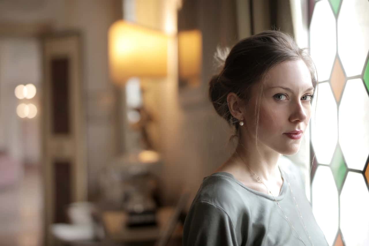 pensive-woman-in-luxury-room-near-window-on-sunny-day-3831110