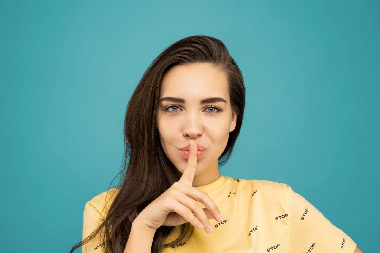 portrait-photo-of-woman-in-yellow-t-shirt-doing-the-shh-sign-3761018