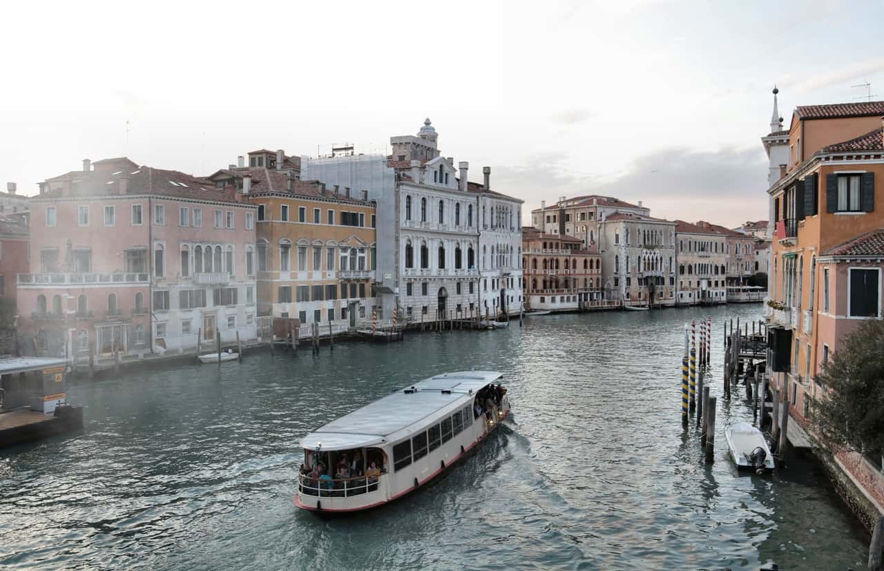 venice-waterway-with-old-buildings-and-ferry-3831085