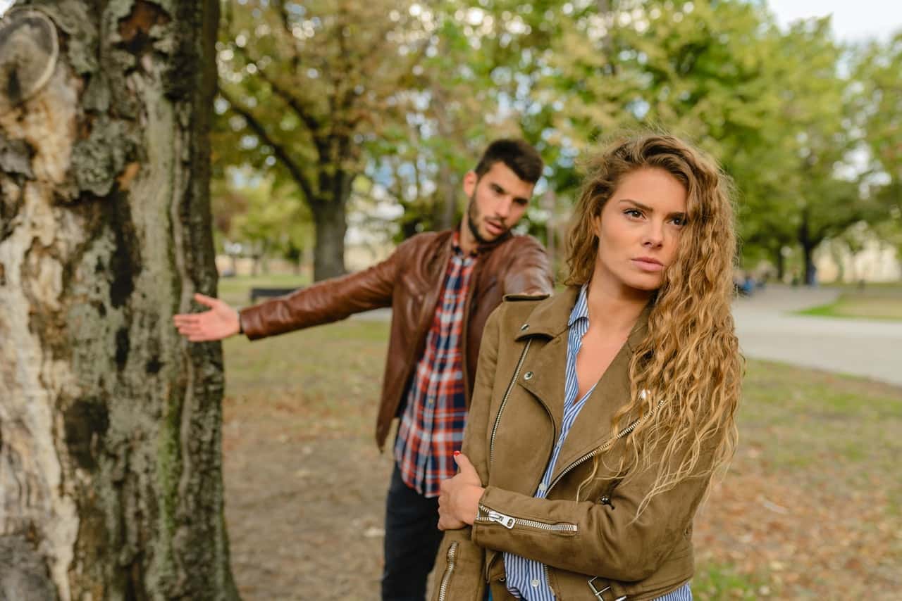woman-and-man-wearing-brown-jackets-standing-near-tree-984954