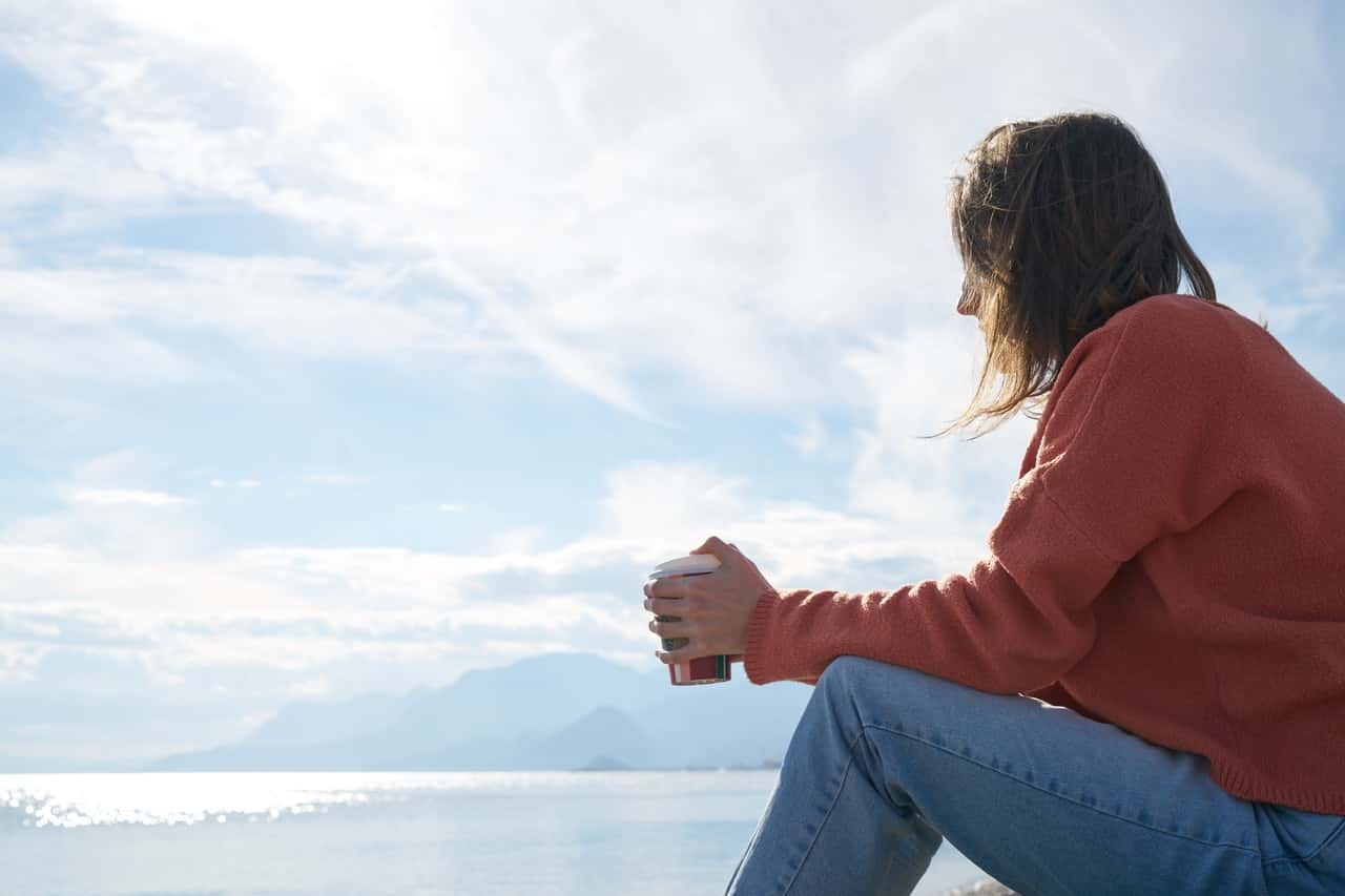 woman-sitting-in-front-of-body-of-water-2174625.jpg
