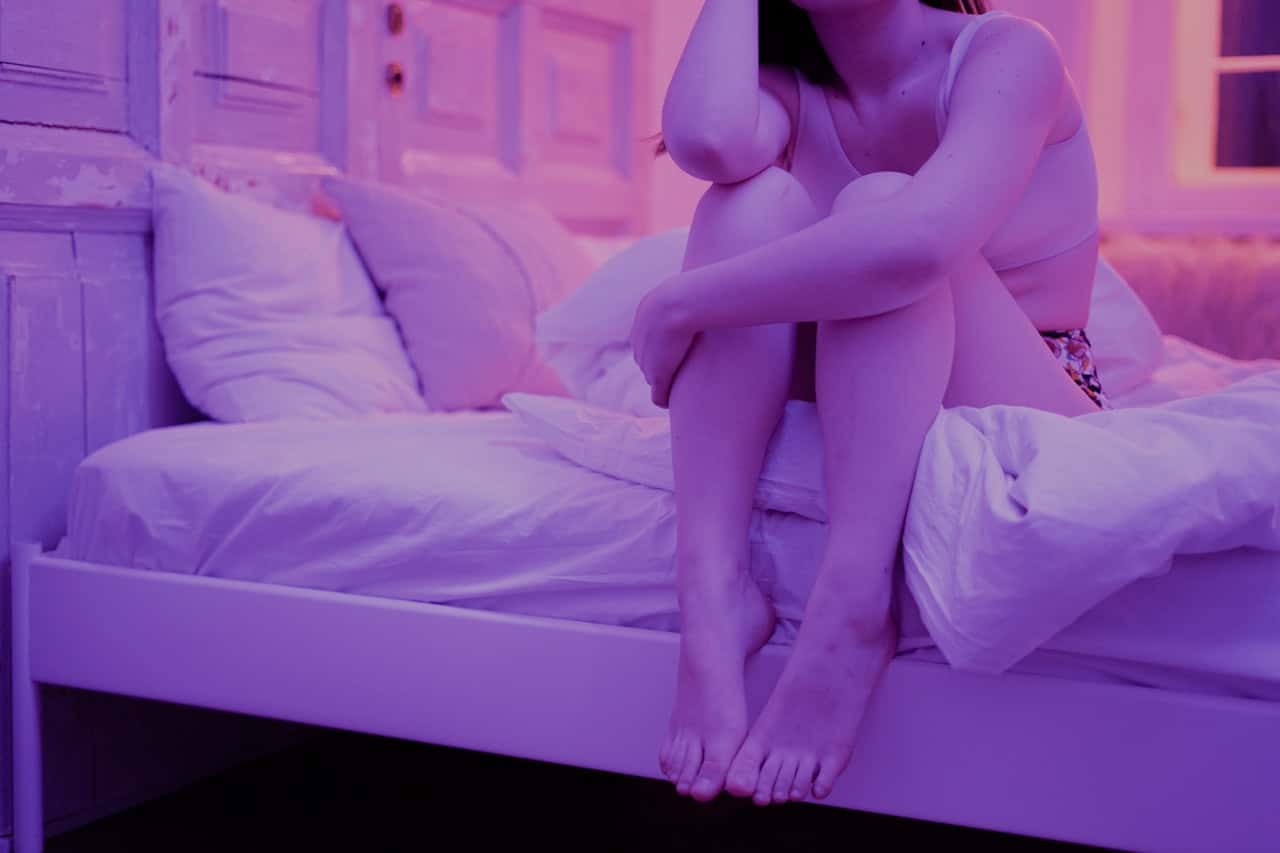 woman-sitting-on-white-bed-3694016
