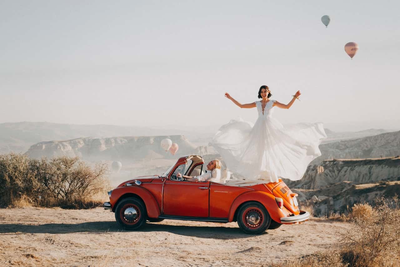 woman-standing-on-volkswagen-beetle-3342697