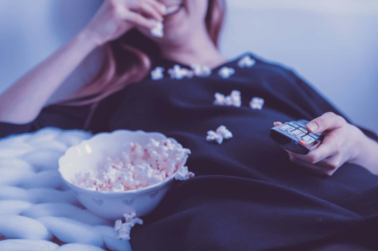 woman-wearing-black-dress-shirt-eating-popcorn-1040159